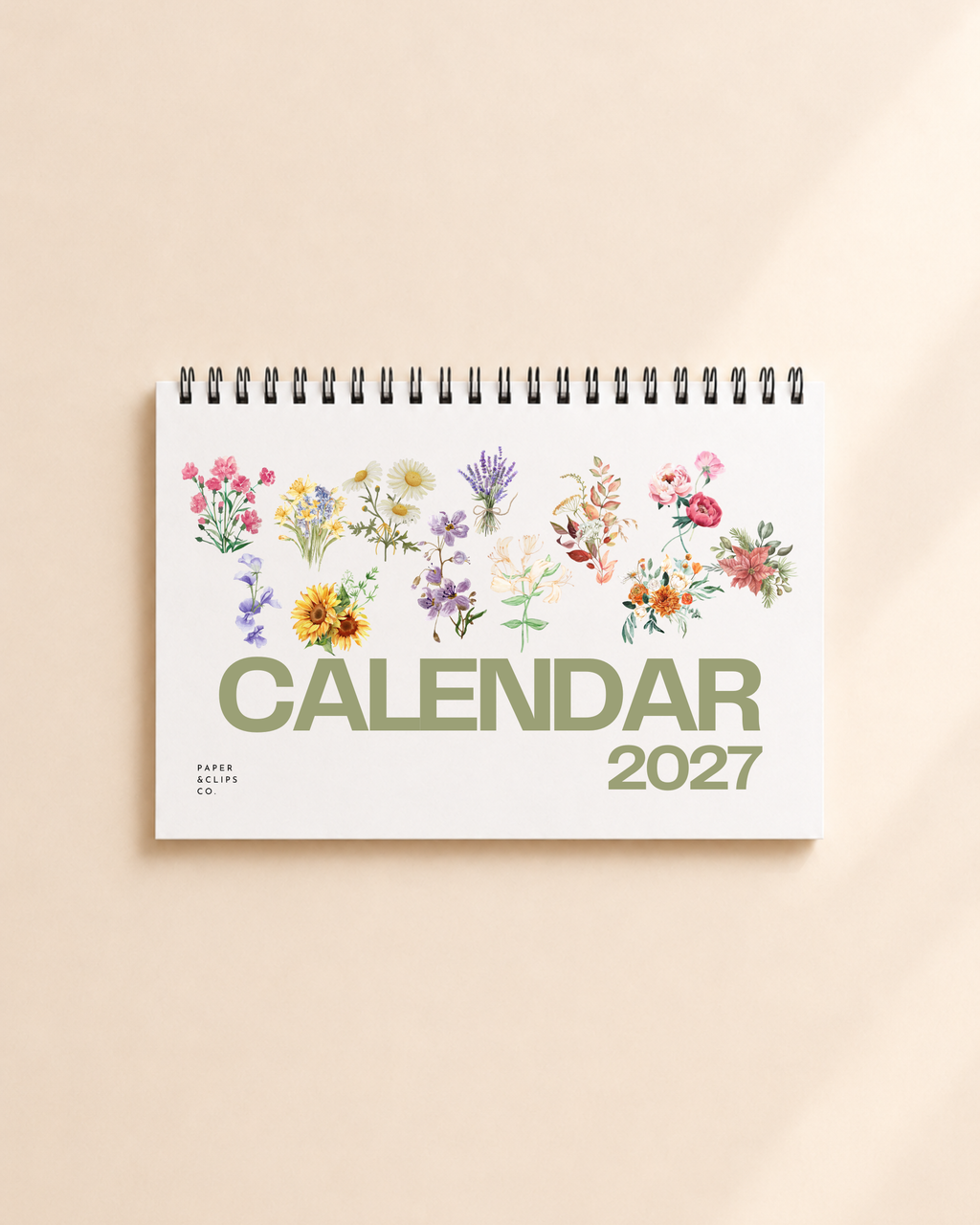 2027 floral desk calendar with botanical flower illustrations on a desktop