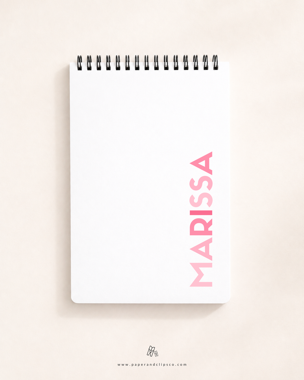 Personalized soft cover top-spiral daily planner featuring custom name "MARISSA" printed vertically on a clean white cover.
