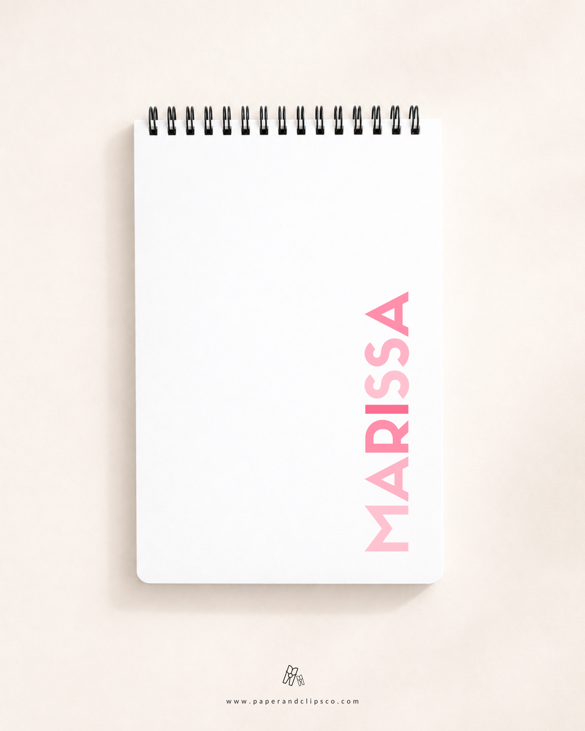 Personalized soft cover top-spiral daily planner featuring custom name "MARISSA" printed vertically on a clean white cover.