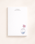 Personalized minimalist floral notepad with hand-drawn flower illustration and custom name, styled on a clean neutral desk.