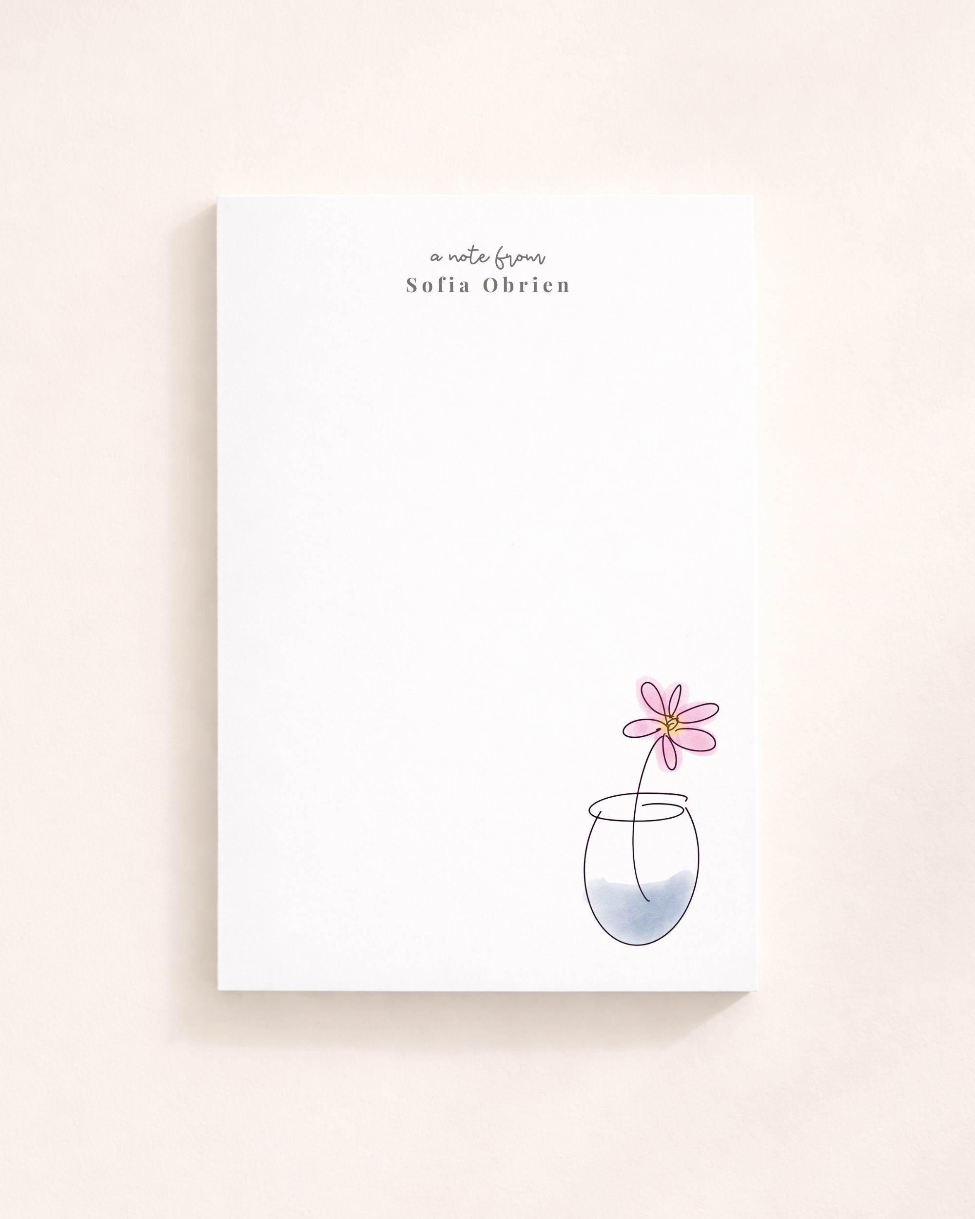 Personalized minimalist floral notepad with hand-drawn flower illustration and custom name, styled on a clean neutral desk.